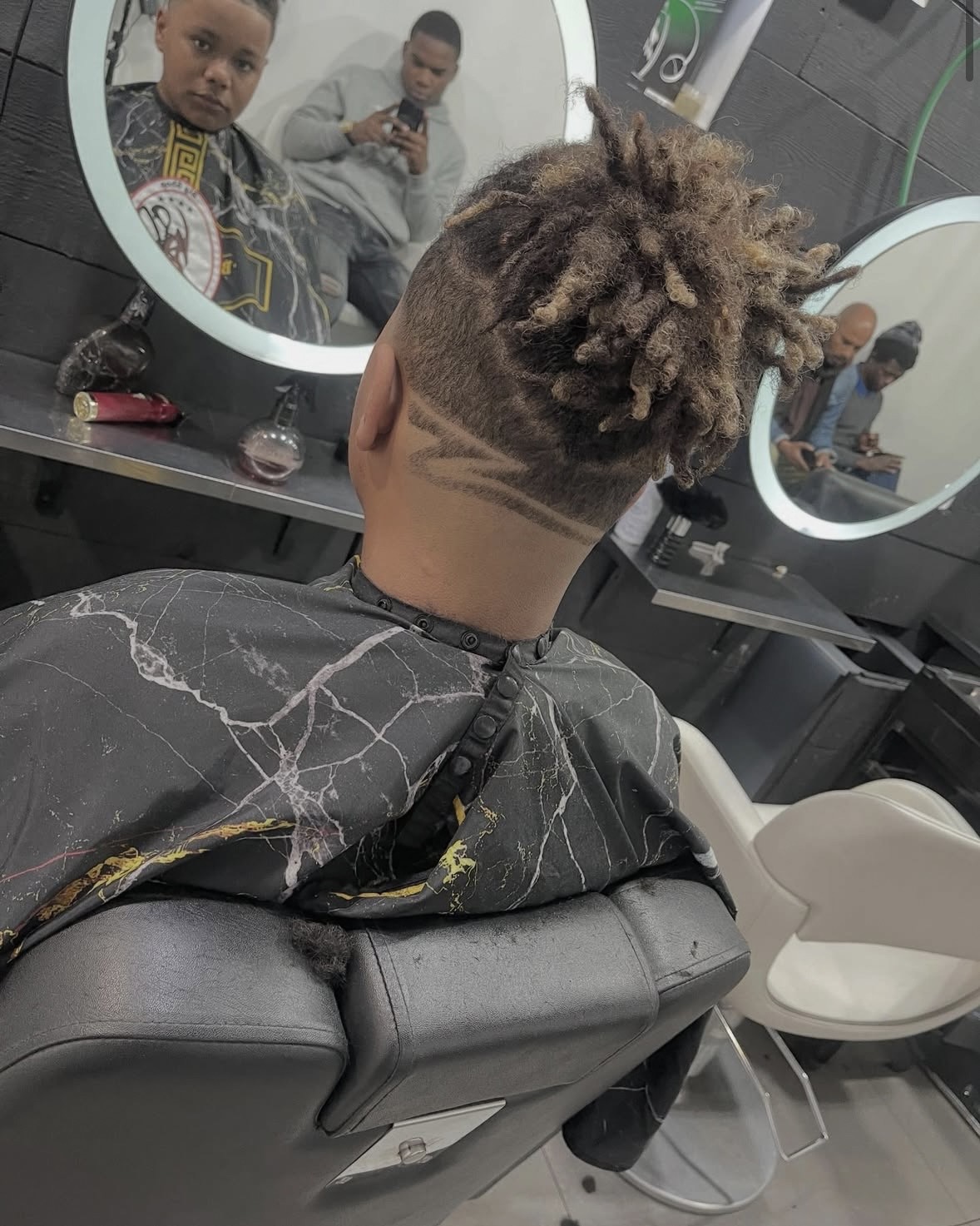 Locs with sculpted line design